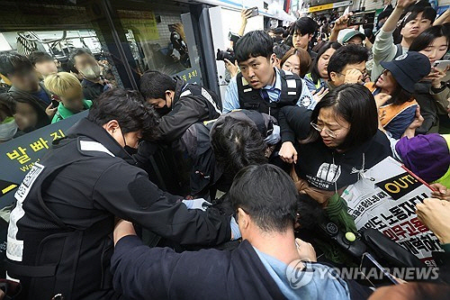 전국장애인차별철폐연대(전장연) 회원들이 21일 서울 지하철 4호선 혜화역에서 제62차 '출근길 지하철 탑니다' 시위를 벌이던 중 지하철 탑승을 시도하며 서울교통공사 직원들과 충돌하고 있다. 전장연이 출근길 지하철 탑승 시위에 나서는 것은 지난해 4월 8일 이후 1년여 만이다. [연합뉴스]